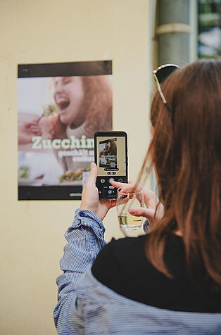 A visitor accessing the films by scanning the QR code on the poster with their smartphone