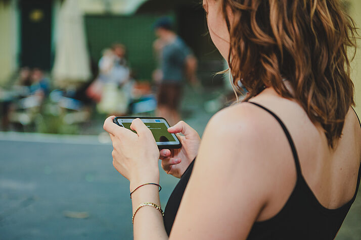 A visitor watching a film on their smartphone